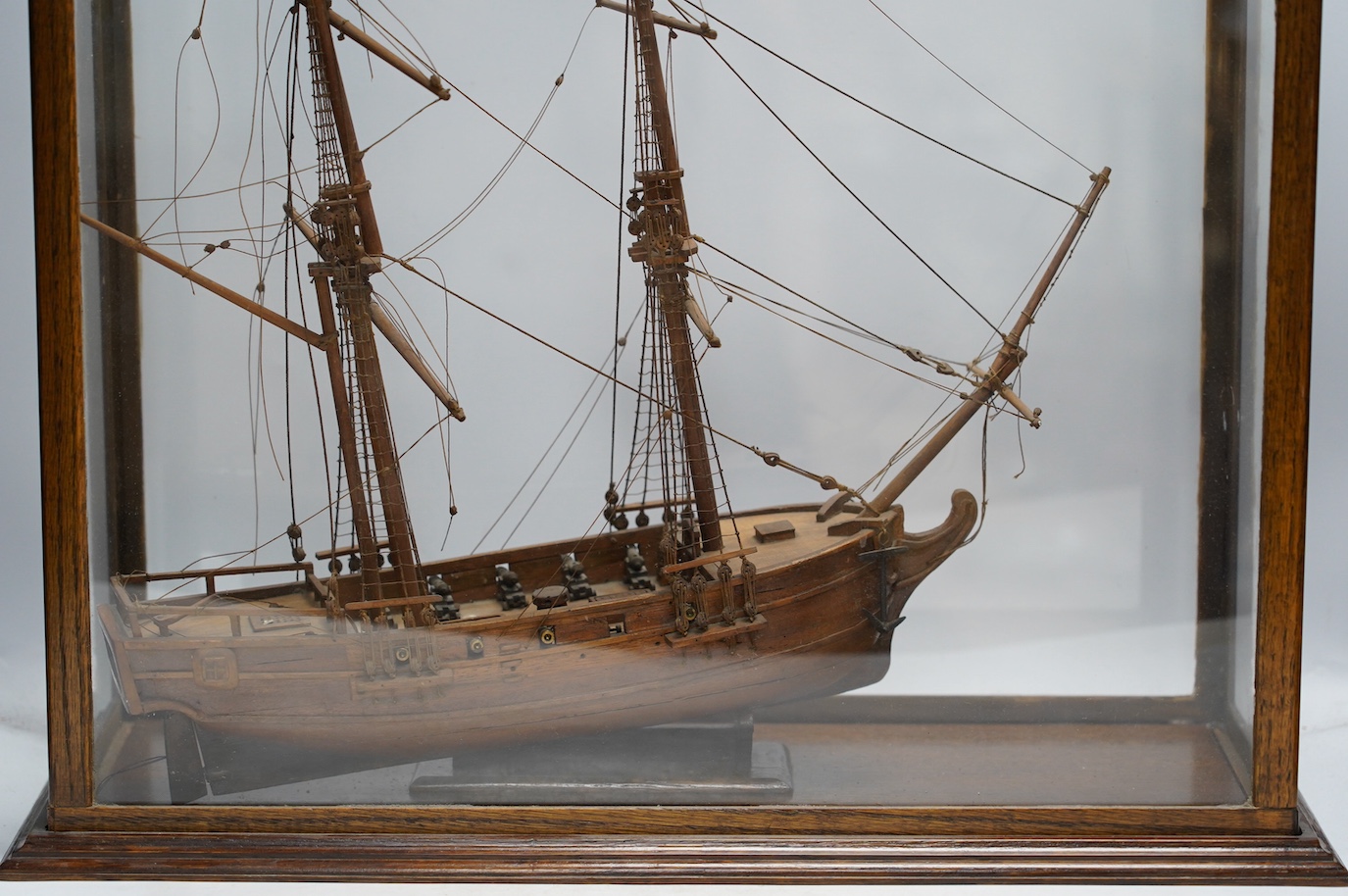 A glazed oak cased model of a ship, case 58cm tall. Condition - fair to good